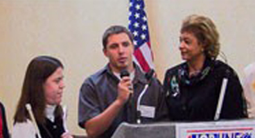 Three Iowa members speak at the convention podium.